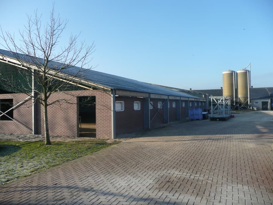 De nieuwe bakstenen kippenstal met twee voersilo's