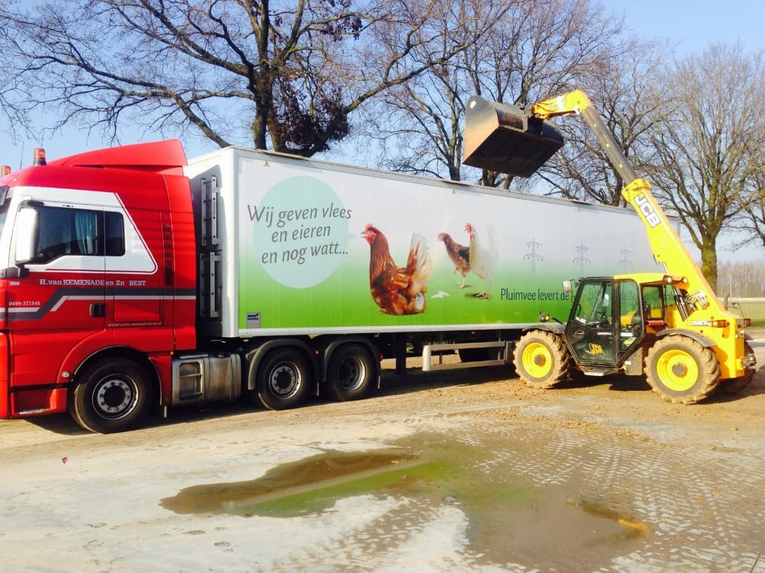 Verreiker laadt kippenmest in een vrachtwagen