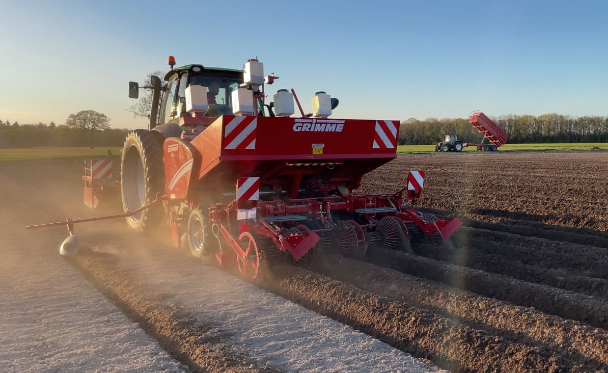 Pootmachine aan het werk in stof en laag zonlicht