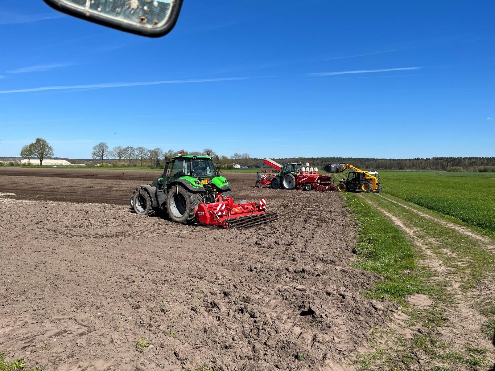 Vanuit de cabine: Deutz met grondbewerker, pootmachine en verreiker op de achtergrond